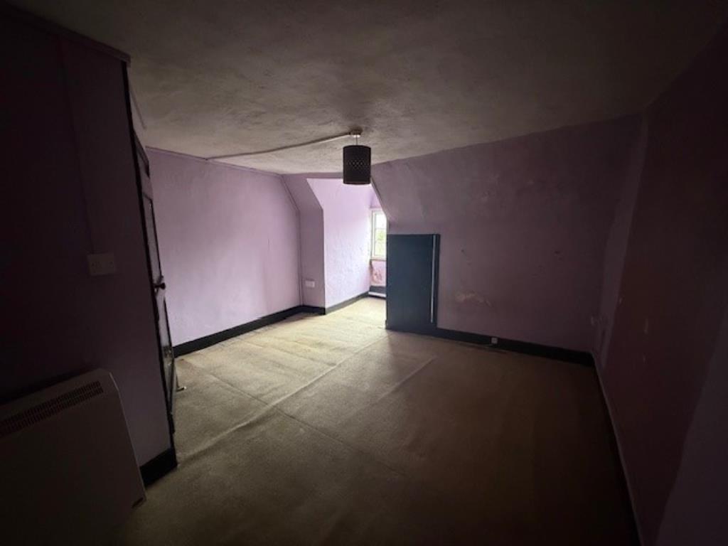 Lot: 115 - A PAIR OF THATCHED COTTAGES IN NEED OF IMPROVEMENT - 48 Abbey Street carpeted bedroom with window